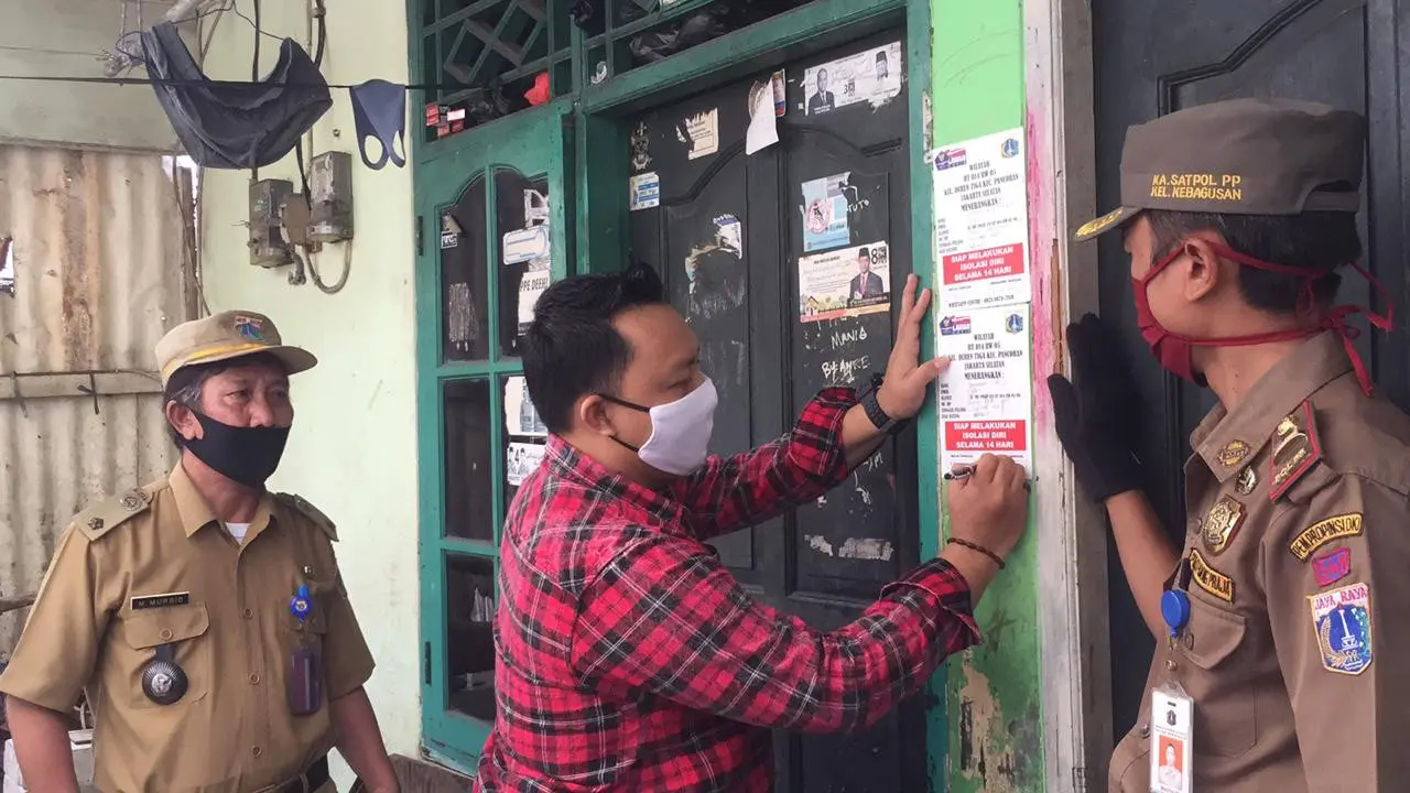 Petugas memasang stiker tempat warga isolasi mandiri
