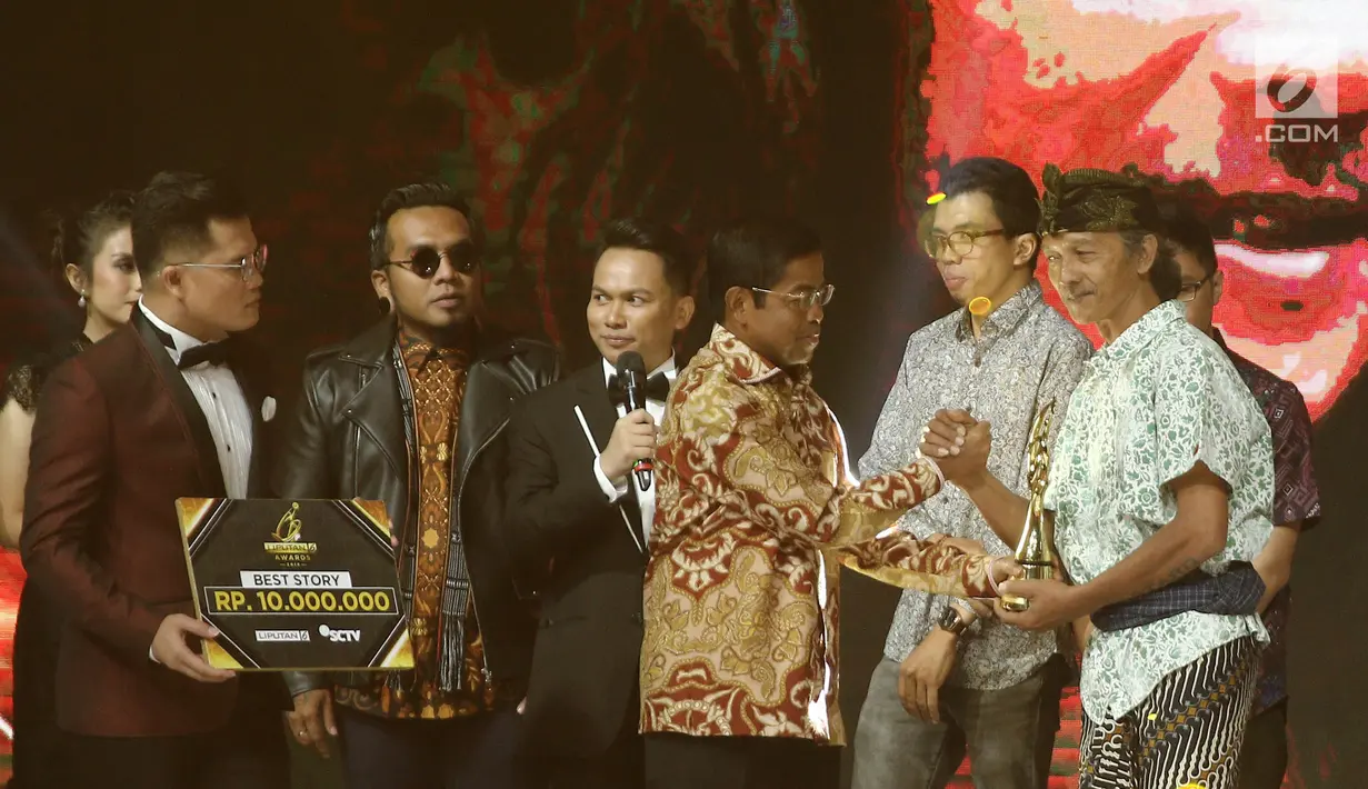 Menteri Sosial Idrus Marham memberikan piala kepada I Putu Gede Paramadipa dalam kategori pelestarian budaya & best story saat ajang Liputan6 Awards 2018 di SCTV Tower, Jakarta, Minggu (20/5). (Liputan6.com/Herman Zakharia)