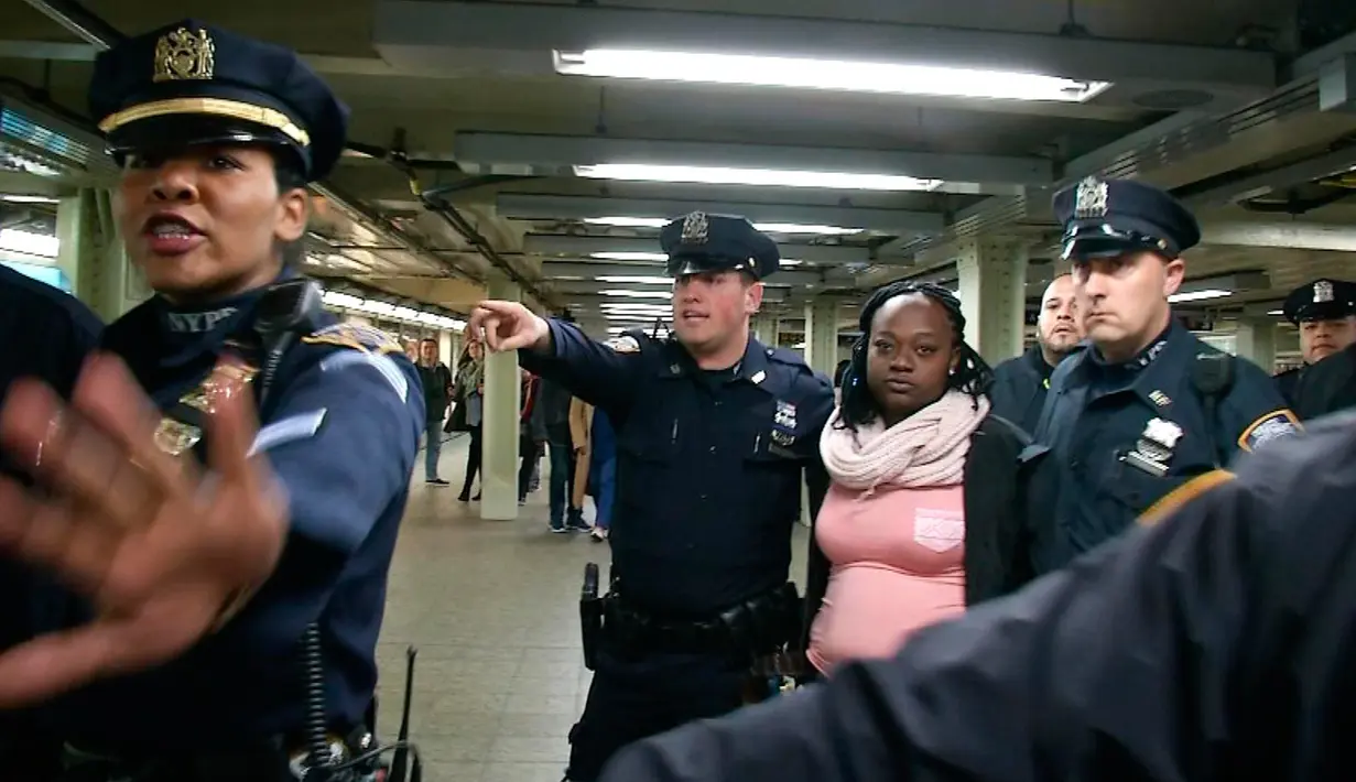 Petugas NYPD menangkap seorang perempuan tersangka pelaku pendorongan di stasiun Time Square, New York, Senin (7/11). Tersangka mendorong seorang perempuan hingga tewas ke jalur subway (kereta bawah tanah) . (REUTERS/James Carman)