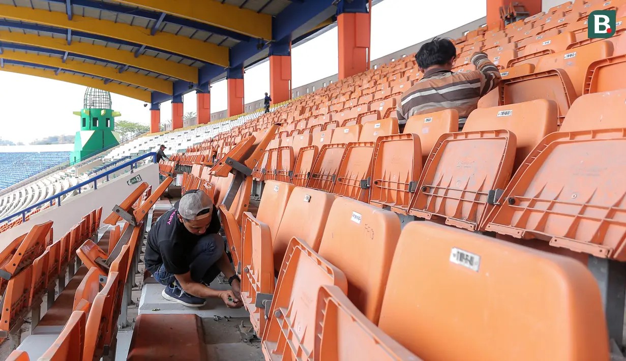 <p>Seorang pekerja memperbaiki bangku tribun penonton di Stadion Si Jalak Harupat (SJH), Bandung, Sabtu (21/10/2023). (Bola.com/Bagaskara Lazuardi)</p>