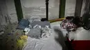 Seorang perempuan duduk dengan dua bayi yang dirawat di rumah sakit pediatri setelah dipindahkan ke ruang bawah tanah yang digunakan sebagai shelter bom di Kiev, Senin (28/2/2022). Tentara Rusia mengatakan, warga sipil Ukraina dapat meninggalkan ibu kota Kiev dengan bebas. (Aris Messinis/AFP)