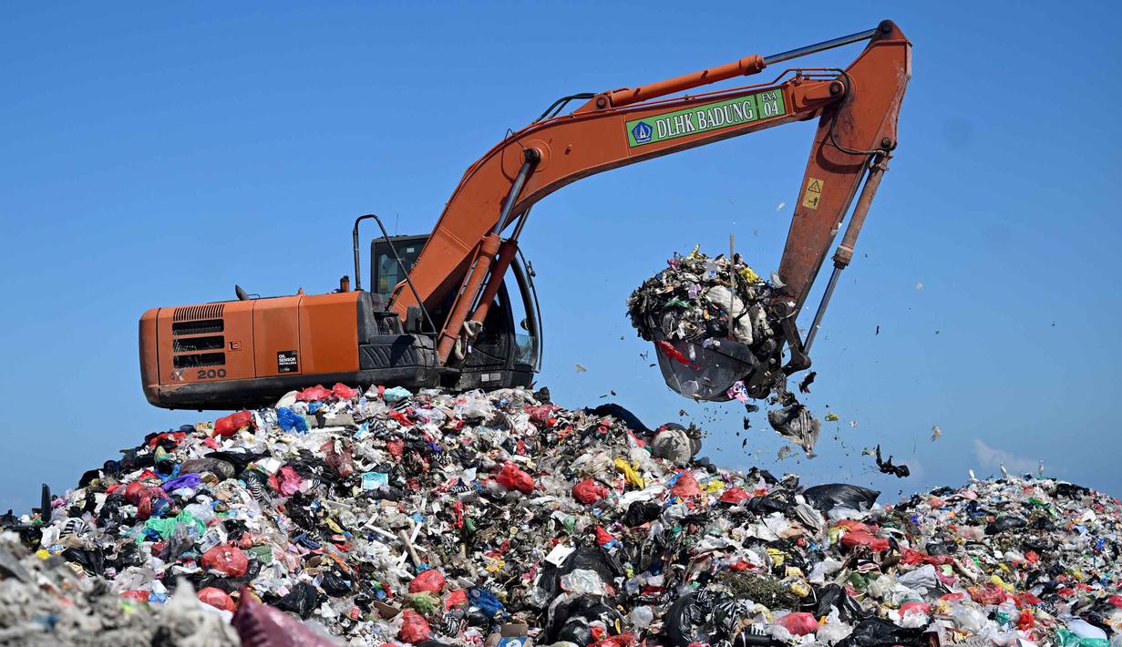 Sebagai informasi, TPA Suwung merupakan tempat pembuangan sampah terbesar di Bali dengan luas total sekitar 32 hektar. Tampak dalam foto, sebuah ekskavator mengangkat sampah di Tempat Pembuangan Akhir (TPA) Suwung, Denpasar, Bali, pada Jumat 17 April 2026. (SONNY TUMBELAKA/AFP)