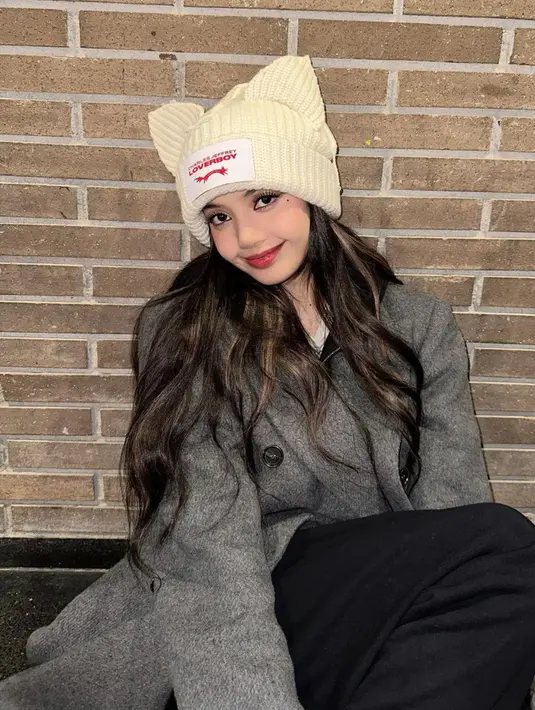 <p>Busana ala musim dingin kali ini Lisa memakai trench coat berwarna abu-abu. Lisa juga menambahkan aksesoris beanie hat berbentuk unik dan lucu. (Instagram/@lalalalisa_m)</p>