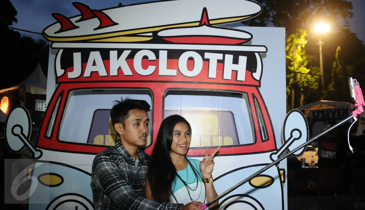 Dua orang pengunjung berfoto di salah satu stand di JakCloth 2015 di Parkir Timur Senayan Jakarta, Rabu (30/12/2015). JakCloth 2015 berlangsung pada 30 Desember 2015 hingga 3 Januari 2016. (Liputan6.com/Helmi Fithriansyah)