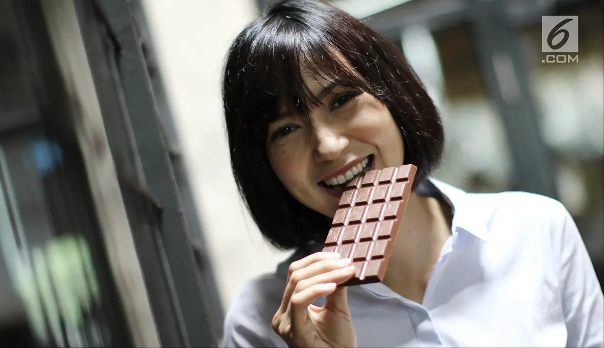 Pemilik Pipiltin Cocoa, Tissa Aunilla menggigit cokelat saat ditemui di tokonya di kawasan Barito, Jakarta, Kamis (13/9). Pipiltin Cocoa dijual dengan kisaran harga mulai Rp 55.000 hingga Rp 58.000 per satuan. (Liputan6.com/Herman Zakharia)