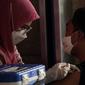 Petugas kesehatan menyuntikkan vaksin booster COVID-19 kepada seorang pria di Pasar Tanah Abang Blok A, Jakarta, Senin (4/4/2022). Vaksinasi yang diselenggarakan Polri ini diikuti warga sekitar dan pedagang Pasar Tanah Abang yang berencana mudik Lebaran. (Liputan6.com/Faizal Fanani)
