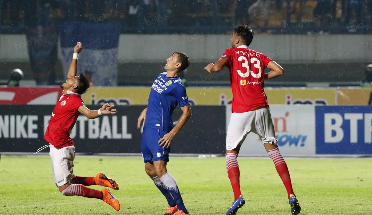 Ekspresi Maman Abdurahman (kiri) saat berebut bola dengan Pemain Persib, Juan Belencoso (tengah) pada laga Torabika SC 2016 antara Persib Bandung melawan Persija Jakarta di GBLA, Bandung, Sabtu (16/7/2016). (Bola.com/Nicklas Hanoatubun)