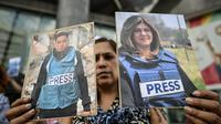 Sejumlah warga Palestina turut berduka atas kematian jurnalis tersebut. Tampak dalam foto, seorang pekerja media pemerintah memegang potret jurnalis Palestina yang telah meninggal selama demonstrasi di depan gedung PBB di Caracas pada 11 Agustus 2025. (Juan BARRETO/AFP)