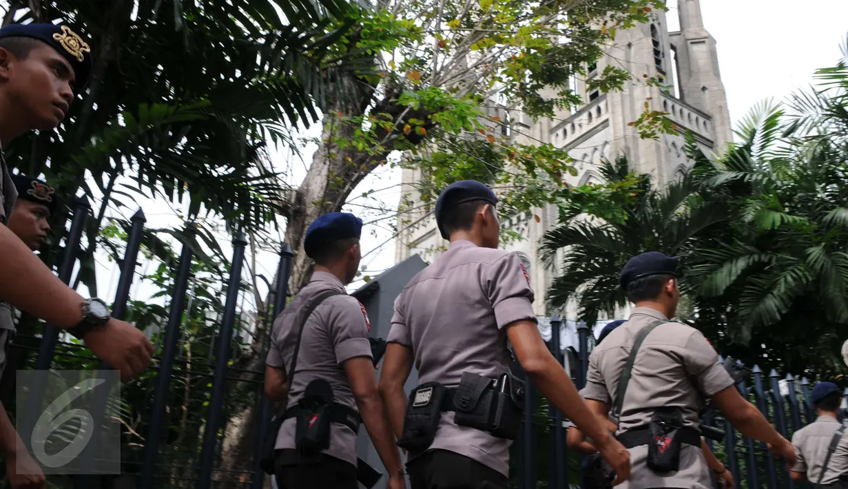 Petugas kepolisian berjaga di sekitar Gereja Katedral, Jakarta, Sabtu (24/12). Penjagaan dilakukan untuk menjaga kondusifitas agar acara Malam Misa Natal bisa berjalan lancar. (Liputan6.com/Helmi Afandi) 