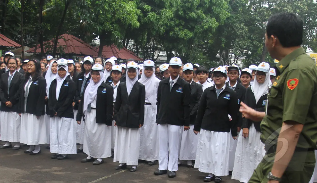 Ratusan siswa SMKN 27 Jakarta saat berkumpul di lapangan untuk mendengarkan pengarahan dari Gubernur DKI Basuki Tjahaja Purnama, Senin (13/4/2015). 293 murid SMKN 27 Jakarta hari ini mengikuti UN hari pertama. (Liputan6.com/Herman Zakharia)