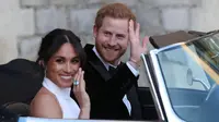 Pangeran Harry dan istrinya Meghan Markle tersenyum saat meninggalkan Kastil Windsor untuk ke acara resepsi dekat Frogmore House (19/5). Mobil yang dikenderai Pangeran Harry yaitu Jaguar Classic E-Type Concept Zero.  (AFP Photo/Pool/Steve Parsons)