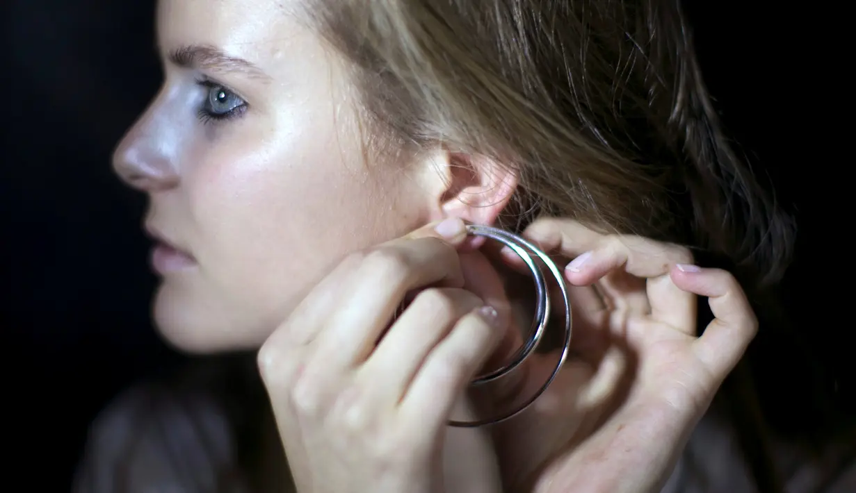Model memasang anting di belakang panggung sebelum memperagakan busana Manning Cartell di bawah jembatan Sydney Harbour Bridge dalam acara Australian Fashion week, 17 Mei 2016. (REUTERS/Jason Reed)
