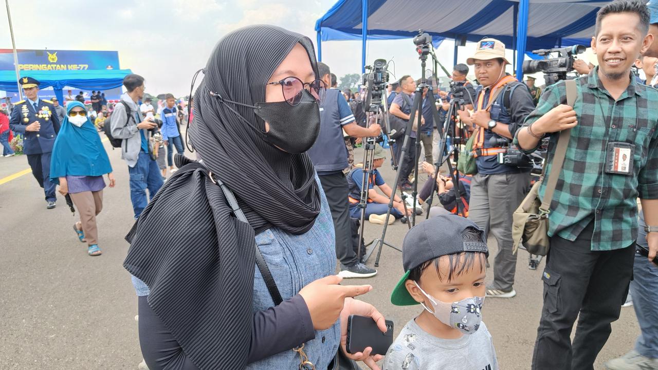 Warga menyaksikan peringatan HUT ke-77 TNI AU di Lanud Halim Perdanakusuma, Minggu (9/4/2023).