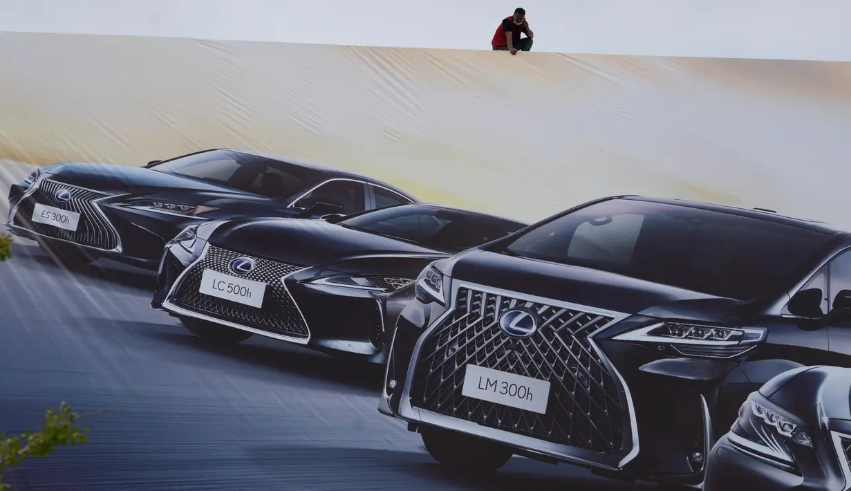 Seorang pekerja mengawasi papan iklan untuk pameran Auto China 2020 yang akan digelar di Beijing, Kamis (24/9/2020). Menandai bangkitnya kembali industri otomotif negara dengan penduduk terbanyak di dunia ini, China mengumumkan siap menggelar Auto China 2020. (AP Photo/Ng Han Guan)
