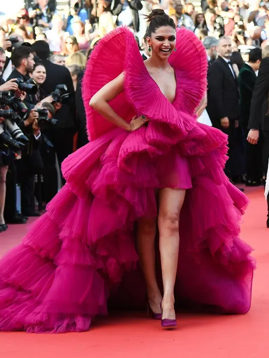 Ia tampil cantik dengan dua gaun yang berbeda. Yang pertama, ia mengenakan gaun warna pink. Gaun ini memamerkan belahan dada dan kakinya yang indah. (AFP/Anne-Christine POUJOULAT)