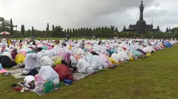 Jamaah muslimah melakukan salat Idul Fitri di dekat Bajra Sandhi di Denpasar, Bali (25/6). Pemerintah Indonesia menetapkan 1 Syawal 1438 H pada Minggu (25/6) setelah menunaikan 29 hari ibadah puasa. (AFP Photo/Sonny Tumbelaka)