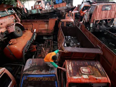 Petugas melakukan pengecekan bangkai armada truk sampah di Kantor Suku Dinas Lingkungan Hidup, Jakarta Barat, Selasa (27/3). Penumpukan armada tersebut dikarenakan kendaraan sudah tidak layak pakai. (Liputan6.com/JohanTallo)