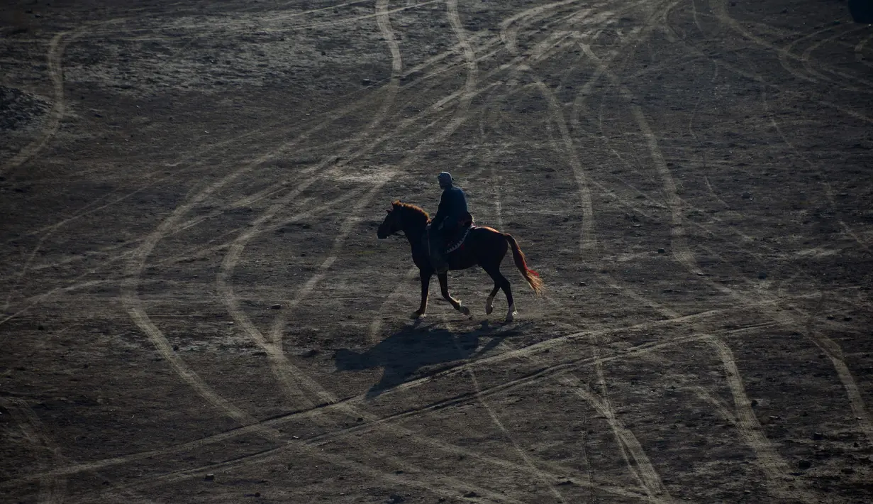 Seorang penunggang kuda bersiap untuk mengikuti pertandingan olahraga tradisional Buzkashi di Mazar-i-Sharif, Afghanistan (20/12). Olahraga ini dimainkan antara dua tim yang bersaing untuk membawa bangkai hewan ke lingkaran. (AFP/Farshad Usyan)