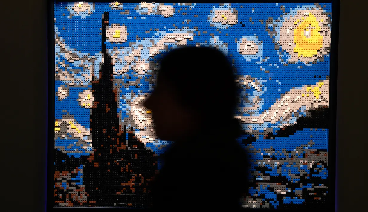 Seseorang berdiri di dekat patung "Starry night" yang terbuat dari susunan balok lego pada pameran Art of the Brick di Turin, Italia, Kamis (15/11). Pameran tersebut menampilkan berbagai patung lego karya seniman AS, Nathan Sawaya. (MARCO BERTORELLO/AFP)