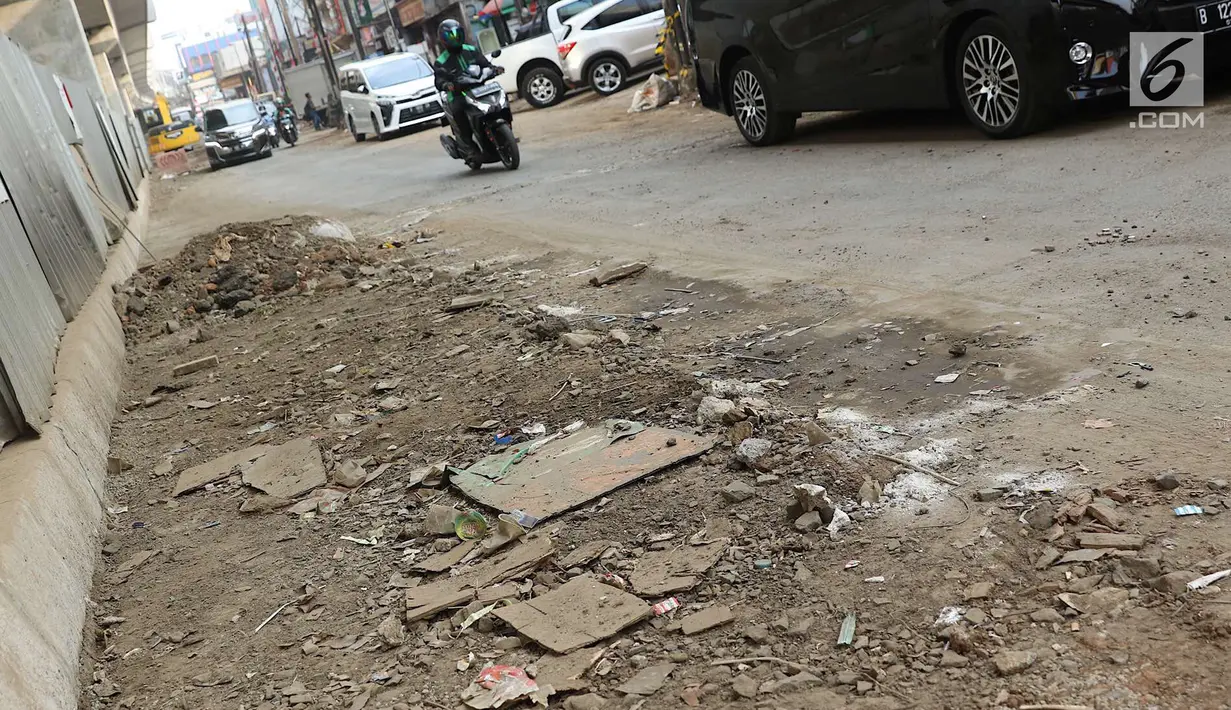 Tanah menggunduk di Jalan Panglima Polim Raya yang mengalami penyempitan, Jakarta, Rabu (8/8). Penyempitan jalan menyebabkan hanya satu jalur yang dapat dilintasi. (Liputan6.com/Immanuel Antonius)