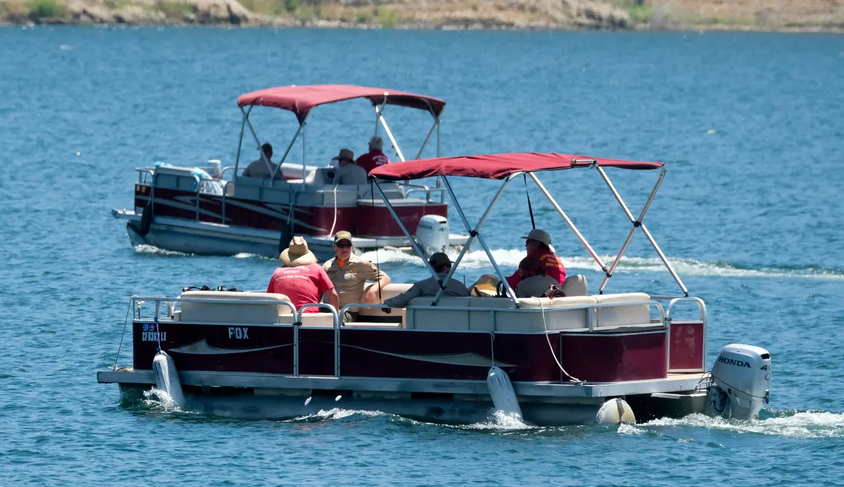 Anggota sheriff Ventura County terlihat di atas kapal di Danau Piru, California, Senin (13/7/2020). Kepolisian wilayah Ventura pada Senin (13/7) pagi mengumumkan telah mengangkat jasad  Naya Rivera dari Danau Piru.  (AP/Ringo H.W. Chiu)