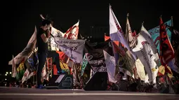 Ratusan penonton konser Syukuran Rakyat Salam 3 Jari mengibarkan bendera atribut di kawasan Monas, Senin (20/10), Jakarta, (20/10/14). (Liputan6.com/Faizal Fanani)