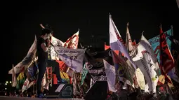 Ratusan penonton konser Syukuran Rakyat Salam 3 Jari mengibarkan bendera atribut di kawasan Monas, Senin (20/10), Jakarta, (20/10/14). (Liputan6.com/Faizal Fanani)