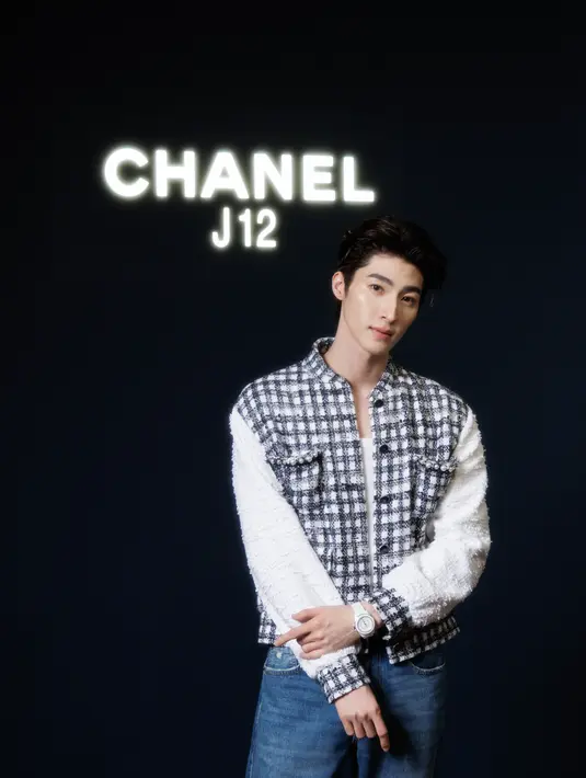 Pongtiwat Tangwancharoen mengenakan atasan jaket model tweed hitam lengan putih. Dipadukan celana denim, serta jam tangan putih. Dok.CHANEL