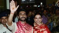 Pasangan bintang Bollywood India, Ranveer Singh dan Deepika Padukone menyapa penggemar yang menyambut mereka di bandara Mumbai, Minggu (18/11). Setelah pacaran selama 5 tahun, Deepika dan Ranveer akhirnya resmi melangsungkan pernikahan di Italia. (AFP)