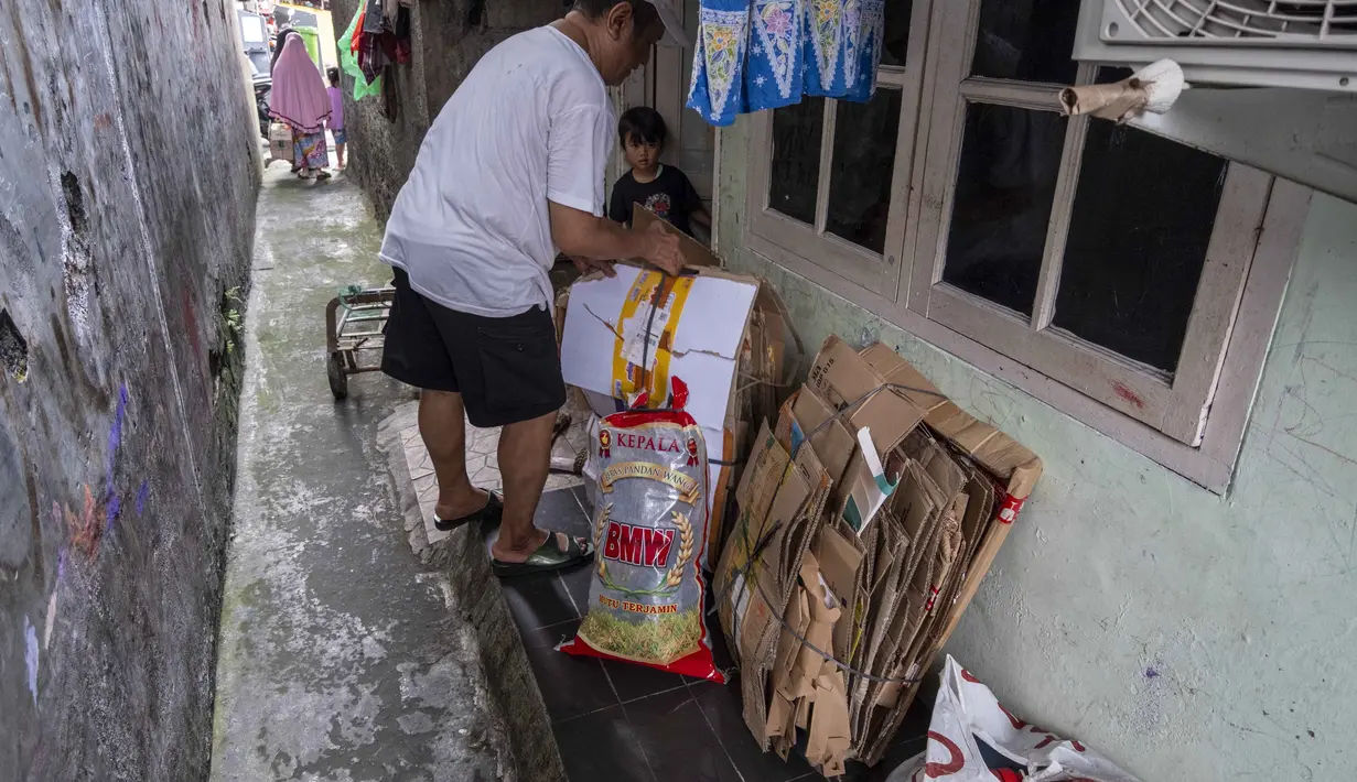 Seorang pria menyiapkan sampah rumah tangga anorganik, berupa kardus dan botol plastik, untuk disetorkan ke bank sampah setempat, Jakarta, Kamis 4 Juni 2026, sebagai bagian dari instruksi Pemprov DKI yang mewajibkan warga memilih dan memilah sampah untuk mengurangi beban sampah yang semakin menumpuk di ibu kota. (BAY ISMOYO/AFP)