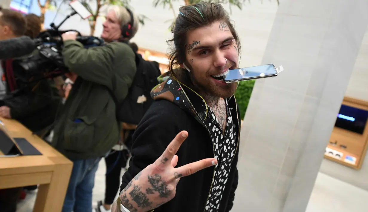 Marco White Jr., putra koki Inggris Marco Pierre White berpose dengan Apple iPhone X-nya setelah ia membelinya di toko Apple's Regent Street di London (3/11). Harga iPhone X sekitar $ 1.000. (AFP Photo/Chris J Ratcliffe)