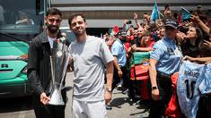 Pemain Timnas Portugal, Bruno Fernandes (kiri) dan Bernardo Silva berfoto bersama dengan fans sambil membawa trofi juara ajang Nations League 2025 setibanya di Bandara Lisbon, Portugal, Senin (09/06/2025) waktu setempat. (AFP/Carlos Costa)