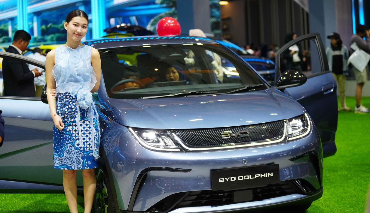 Kehadiran model-model ini, mulai dari SUV hingga MPV, menegaskan arah industri otomotif Indonesia yang kian mengarah pada elektrifikasi. Tampak dalam foto, seorang model berdiri di dekat BYD Dolphin, kendaraan listrik dari produsen mobil Tiongkok BYD, selama Pameran Otomotif Internasional Indonesia di Jakarta, Sabtu 7 Februari 2026. (AP Photo/Tatan Syuflana)