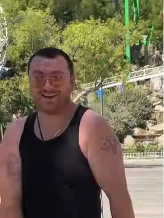 Sebelum masuk ke taman hiburan dan bermain wahana, Sam Smith, melenturkan otot-otot badannya dengan bergoyang di depan pintu masuk. (Foto: Instagram/@samsmith)