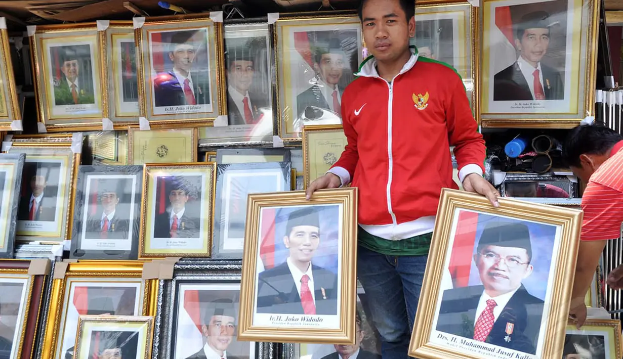 Foto resmi kenegaraan Presiden Joko Widodo atau Jokowi dan Wakil Presiden Jusuf Kalla dijajakan pedagang di Pasar Baru, Jakarta, (25/10/2014). (Liputan6.com/Miftahul Hayat)