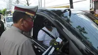 Polantas Polres Bogor memeriksa surat domisili pengemudi mobil  yang melintasi Pos Pengawasan Larangan Mudik di Cigombong, Bogor, Rabu (29/4/2020). (merdeka.com/Arie Basuki)