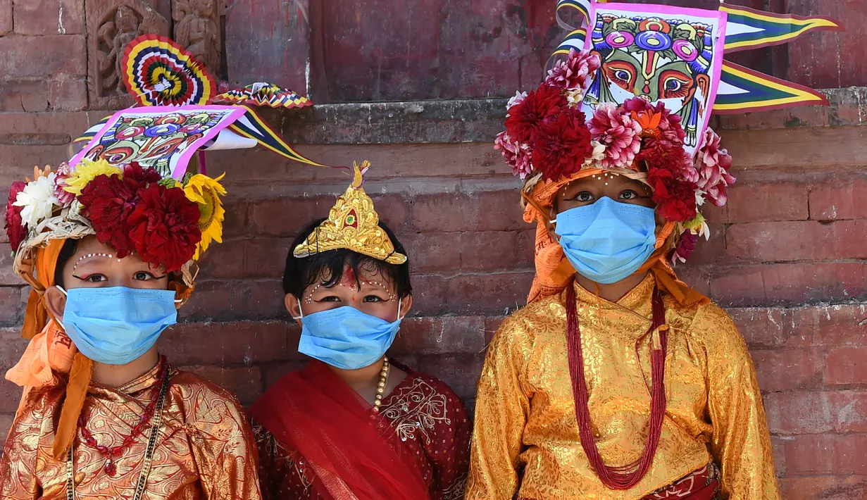 Anak-anak Nepal mengenakan masker dan kostum sapi tradisional saat berpartisipasi dalam prosesi 'Gai Jatra', atau festival sapi, di Kathmandu, Selasa (4/8/2020). Festival ini untuk meminta keselamatan dan kedamaian bagi orang yang mereka cintai yang telah meninggal. (PRAKASH MATHEMA/AFP)