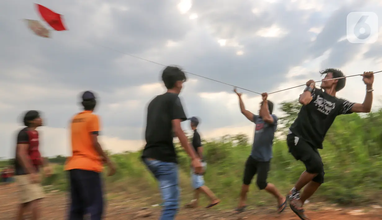 Warga menahan layang-layang merah putih raksasa sebelum diterbangkan di kawasan Bambu Apus, Tangerang Selatan, Senin (17/8/2020). Layangan berukuran 10 X 9 meter yang ditarik menggunakan tambang diterbangkan dalam rangka memperingati HUT Ke-75 RI. (Liputan6.com/Fery Pradolo)