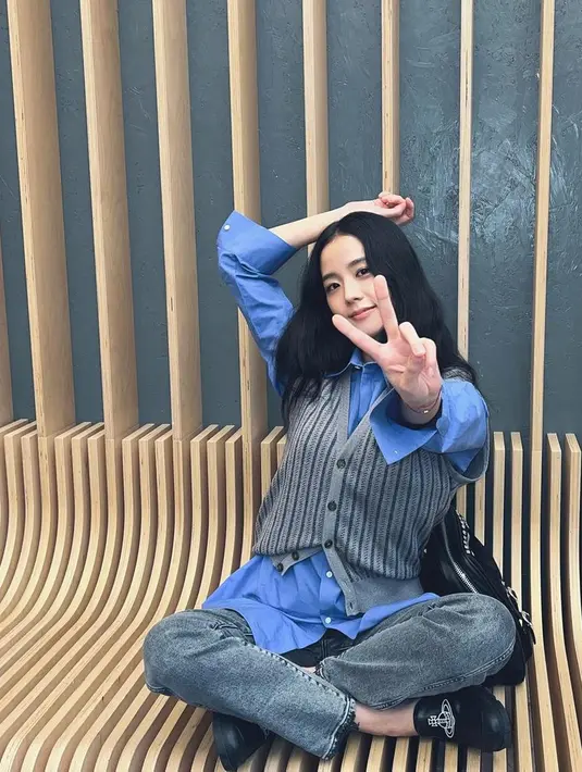 Tampil kasual mengenakan vest knitwear ala Jisoo Blackpink, cukup padukan dengan kemeja lengan panjang dan celana denimnya. [@sooyaaa_]