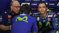 Pebalap Movistar Yamaha, Valentino Rossi, berdiskusi saat sesi latihan kedua jelang GP Malaysia di Sirkuit Sepang, Jumat (27/10/2017). Pada sesi ini pebalap Italia itu berada pada posisi keenam dengan waktu 13,071 detik. (AFP/Mohd RASFAN)