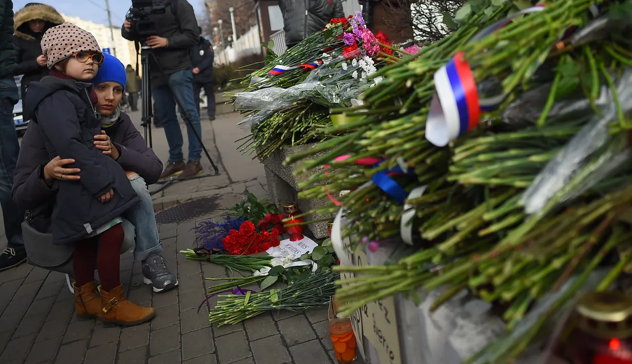 Warga Moskow melihat karangan bunga di luar Kedutaan Besar Prancis di Moskow, Sabtu (14/11/2015) . Karangan bunga tersebut untuk menghormati para korban serangan mematikan di Paris. (AFP Photo/Dmitry Serebryakovi)