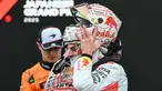 Pembalap Red Bull Racing asal Belanda, Max Verstappen (kanan) melepas helmnya setelah kemenangannya pada Fomula 1 Grand Prix Jepang di sirkuit Suzuka, prefektur Mie, Jepang pada 6 April 2025. (Toshifumi KITAMURA/AFP)
