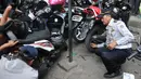 Petugas mencopot pentil motor saat melakukan razia parkir liar di kawasan Tanah Abang, Jakarta, Rabu (3/6/2015). Meski sudah disosialisasikan, kenyataannya masih banyak orang yang tak menghiraukan peraturan tersebut. (Liputan6.com/Johan Tallo)