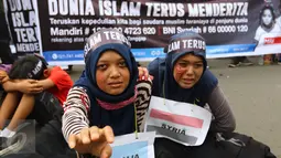 Dua demonstran dengan bendera Syria dan Somalia yang dikalungkan di leher, melakukan aksi keprihatinan saat CFD di Bundaran HI, Jakarta (14/08). (Liputan6.com/Fery Pradolo).