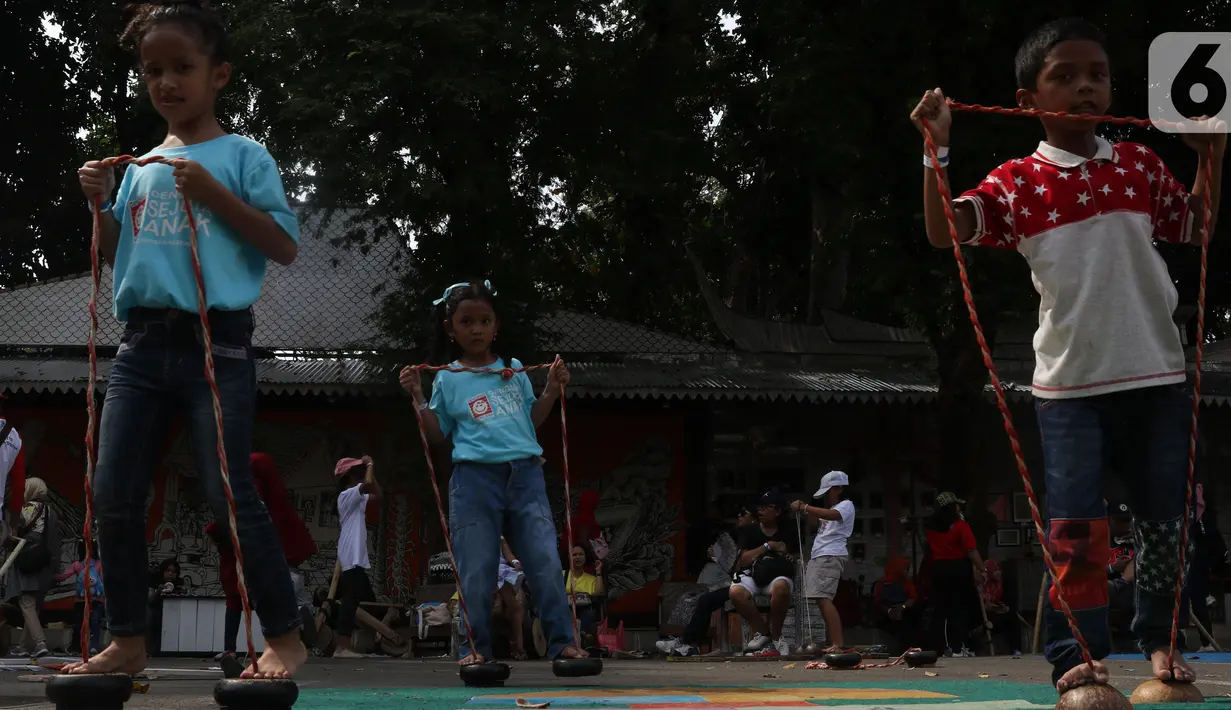 Anak-anak bermain egrang batok pada Pekan Kebudayaan Nasional di Istora Senayan, Jakarta, Sabtu (12/10/2019). Perhelatan yang digelar Direktorat Jenderal Kebudayaan Kemendikbud RI itu menampilkan pagelaran seni dan budaya Indonesia, termasuk aneka permainan tradisional. (Liputan6.com/Angga Yuniar)