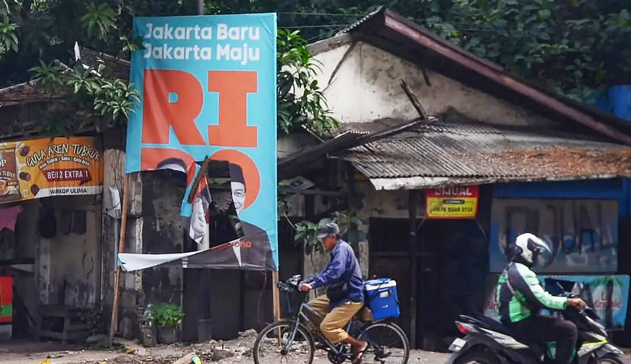 Pengguna jalan melewati baliho kampanye pasangan cagub-cawagub Jakarta nomor urut 1 Ridwan Kamil (RK)-Suswono yang rusak di Jalan Bekasi Raya, Klender, Jakarta Timur, Senin (11/11/2024). (merdeka.com/Arie Basuki)