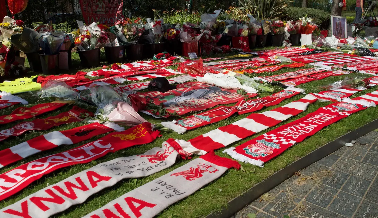 Karangan bunga berikut syal diletakkan di luar Stadion Anfield, Liverpool, Inggris, sebagai bentuk pemghormatan usai pemain sepak bola asal Portugal Diogo Jota yang dinyatakan meninggal dunia pada Kamis (3/7/2025). (Paul BARKER/AFP)