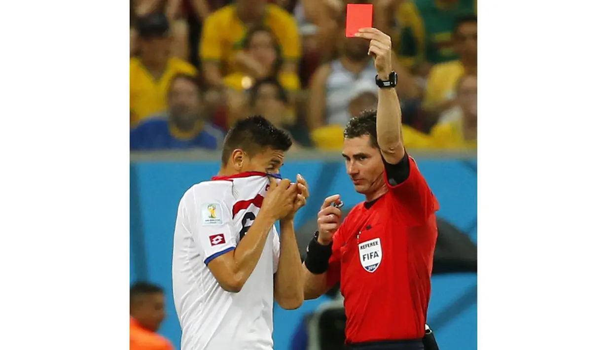 Pemain belakang Timnas Kosta Rika, Oscar Duarte (kiri) diganjar kartu merah oleh wasit Benjamin Williams (Australia) saat berlaga di 16 besar Piala Dunia 2014 di Stadion Pernambuco, Recife, (30/6/2014). (REUTERS/Yves Herman) 