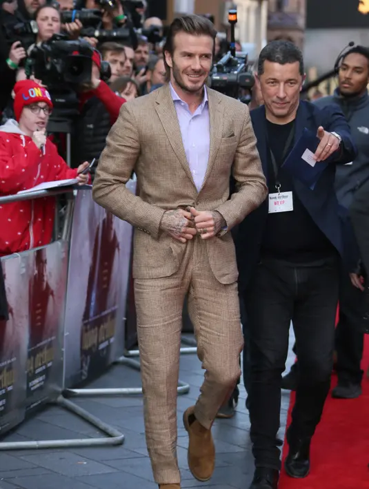 Senyum David Beckham saat menghadiri pemutaran perdana film 'King Arthur The Legend Of The Sword' ', di London, Inggris (10/5). Mantan pesekbola ini tampil keren dengan busana dan sepatu serba coklat. (Photo by Joel Ryan/Invision/AP)