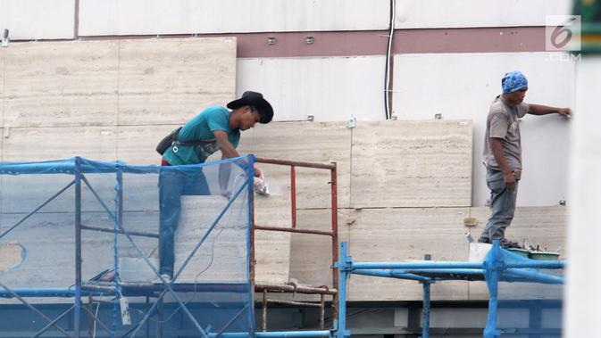 Pekerja mengerjakan pemasangan dinding di salah satu bangunan di Jakarta, Selasa (15/1). Sektor kecelakaan kerja paling banyak masih dibidang konstruksi. (Liputan6.com/Angga Yuniar)